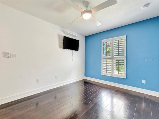 empty room featuring dark wood-type flooring and ceiling fan