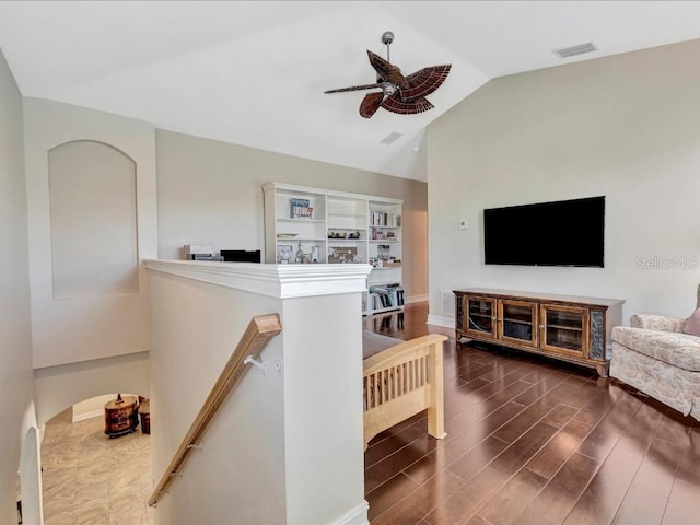 living room featuring vaulted ceiling, ceiling fan, and dark wood-type flooring