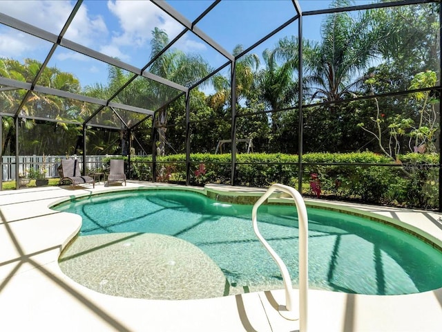 view of pool featuring a patio, glass enclosure, and pool water feature