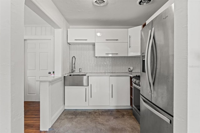 kitchen featuring sink, white cabinets, light hardwood / wood-style flooring, stainless steel appliances, and decorative backsplash