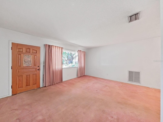 carpeted spare room featuring a textured ceiling