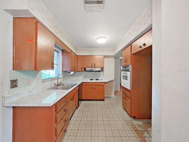 kitchen featuring backsplash, white oven, exhaust hood, and sink