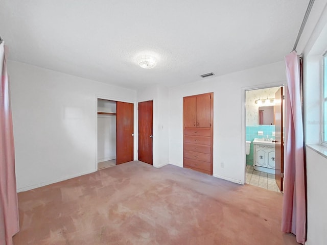 unfurnished bedroom with light colored carpet and ensuite bathroom