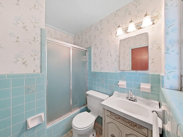 bathroom with tile walls, vanity, and toilet