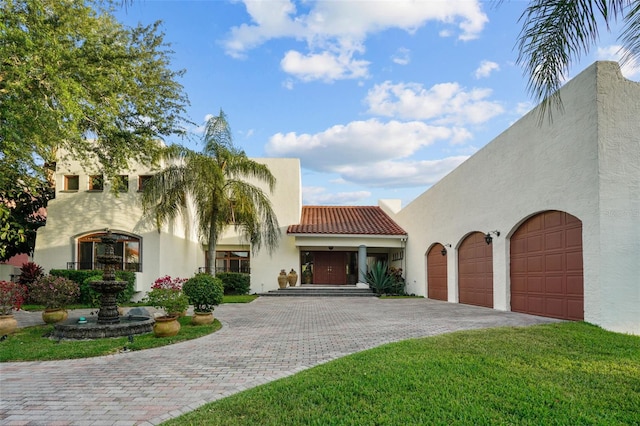 mediterranean / spanish house with a front yard and a garage