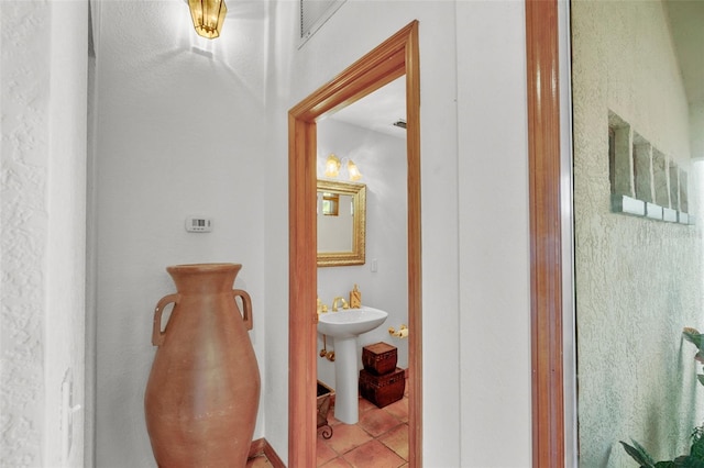 hall featuring tile patterned flooring and sink