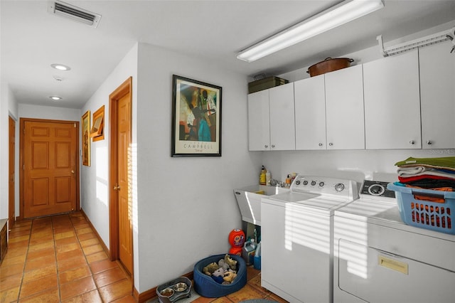 clothes washing area with cabinets, light tile patterned flooring, washing machine and clothes dryer, and sink