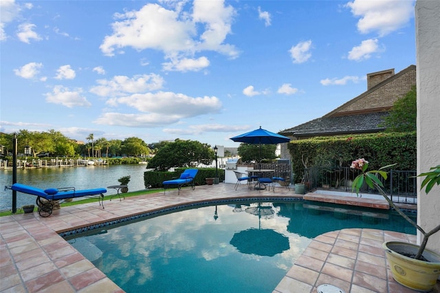 view of pool featuring a water view and a patio