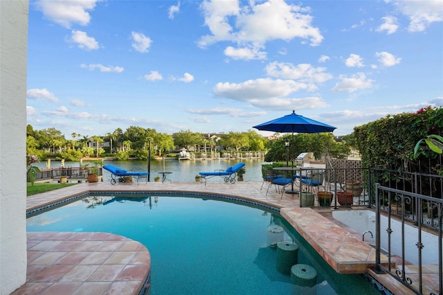 view of swimming pool featuring a water view and a patio