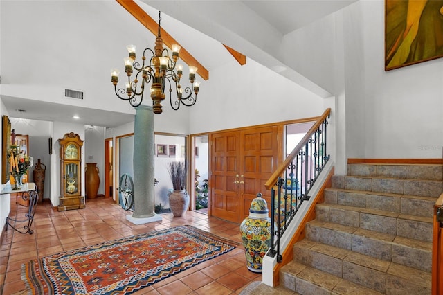 tiled foyer entrance with a chandelier and a high ceiling