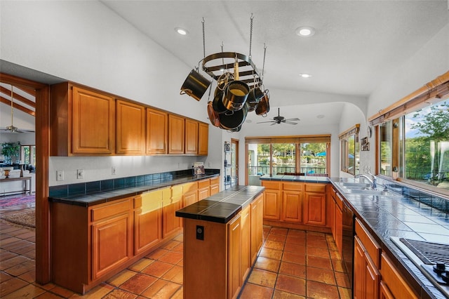 kitchen with a kitchen island, sink, stainless steel gas cooktop, kitchen peninsula, and ceiling fan