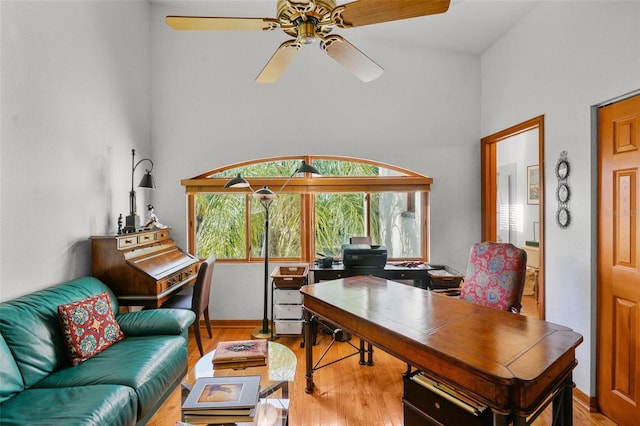 office with ceiling fan, a high ceiling, and light hardwood / wood-style flooring