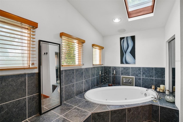 bathroom featuring tiled bath, a wealth of natural light, tile patterned floors, and vaulted ceiling with skylight