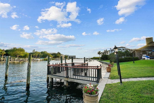 view of dock with a water view and a yard