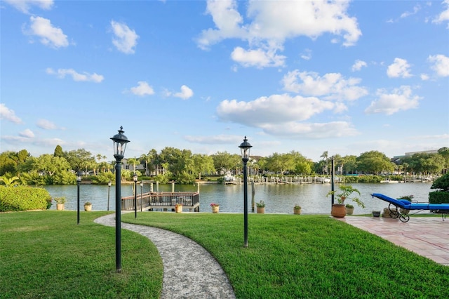 view of community with a water view and a yard