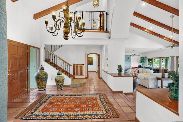 entrance foyer with ceiling fan with notable chandelier, tile patterned floors, beam ceiling, and high vaulted ceiling