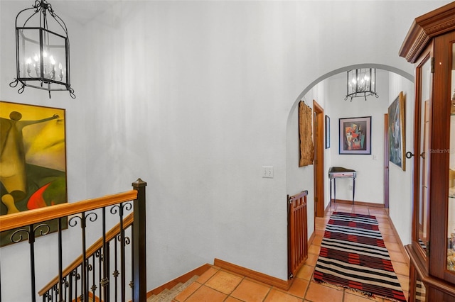 hall featuring light tile patterned floors and a notable chandelier