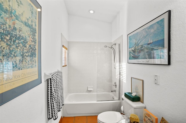 bathroom featuring toilet, a wealth of natural light, tiled shower / bath, and tile patterned floors