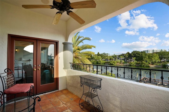 balcony featuring a water view and ceiling fan