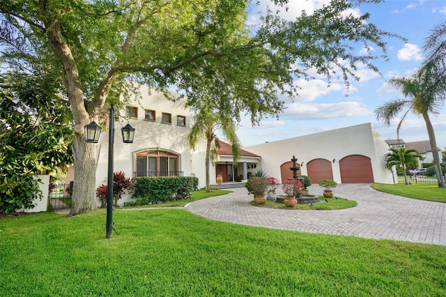 mediterranean / spanish-style house featuring a front yard and a garage