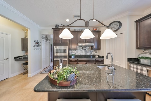 kitchen with sink, an island with sink, and stainless steel appliances