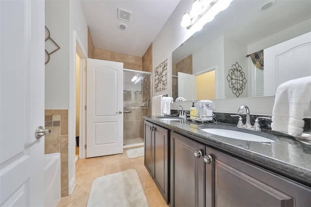 bathroom featuring tile flooring, dual sinks, oversized vanity, and a textured ceiling