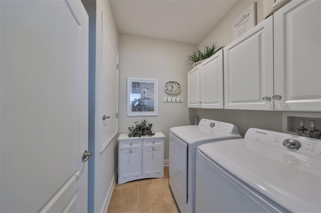 laundry room featuring cabinets, washer hookup, light tile floors, and washer and clothes dryer