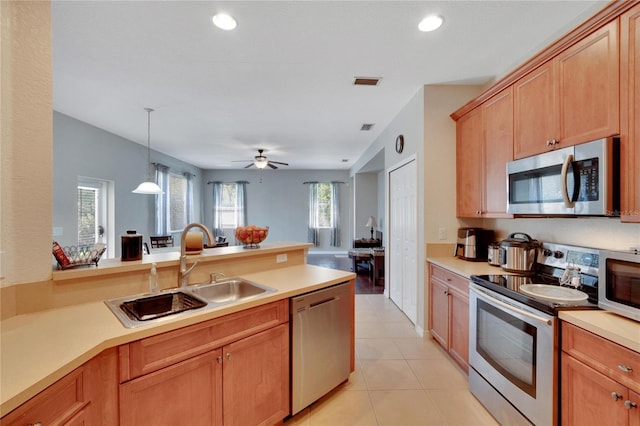 kitchen with decorative light fixtures, stainless steel appliances, sink, light tile patterned flooring, and ceiling fan