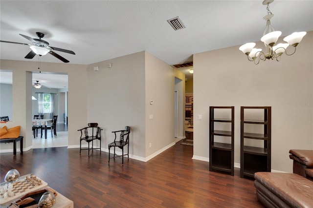 interior space with dark wood-type flooring and ceiling fan with notable chandelier