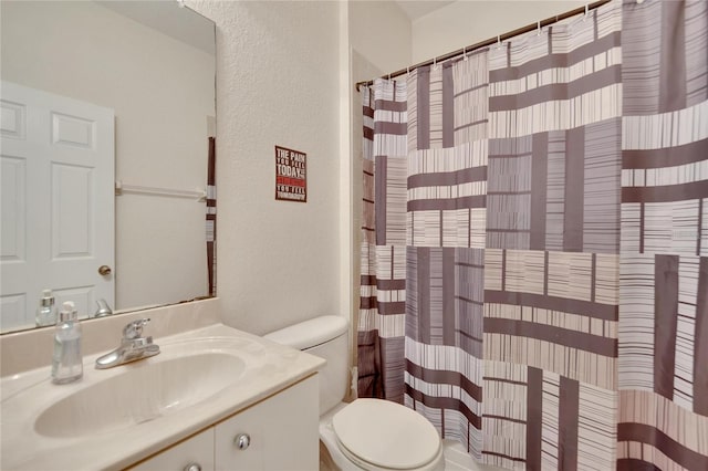 bathroom featuring vanity, toilet, and curtained shower