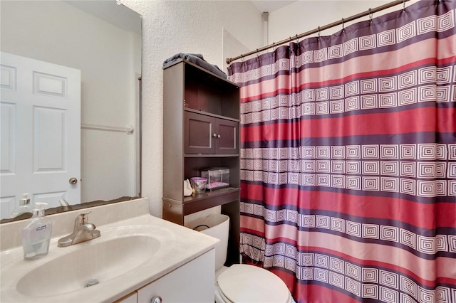 bathroom with curtained shower, toilet, and vanity