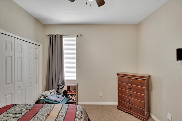 carpeted bedroom with ceiling fan and a closet