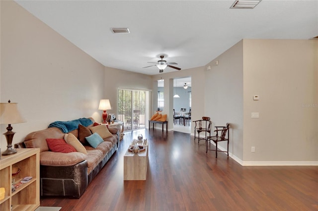 living room with ceiling fan and dark hardwood / wood-style flooring