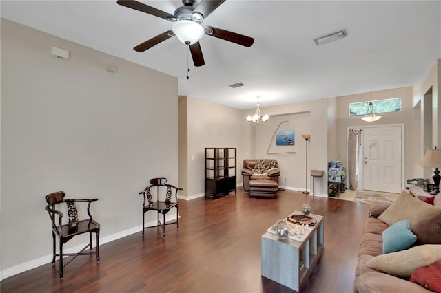 living room featuring ceiling fan with notable chandelier and dark hardwood / wood-style flooring