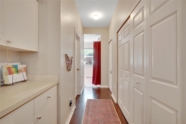 hall with dark hardwood / wood-style flooring and a textured ceiling