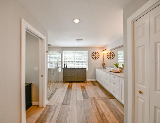 bathroom with a shower with door, vanity, and hardwood / wood-style flooring