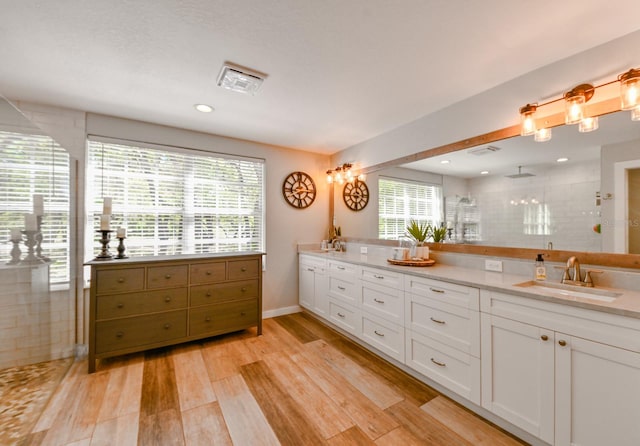 bathroom with wood-type flooring, plenty of natural light, and double sink vanity