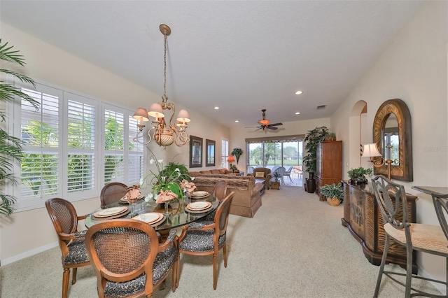 dining area with light colored carpet and ceiling fan with notable chandelier