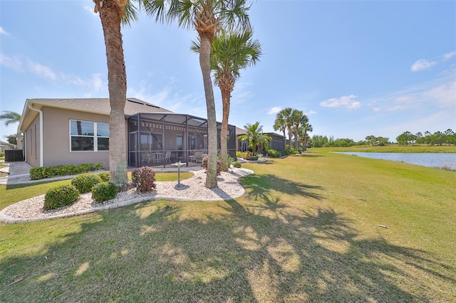 view of yard featuring a water view, central AC unit, and glass enclosure