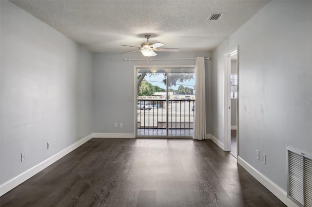 empty room featuring a textured ceiling, dark hardwood / wood-style floors, and ceiling fan