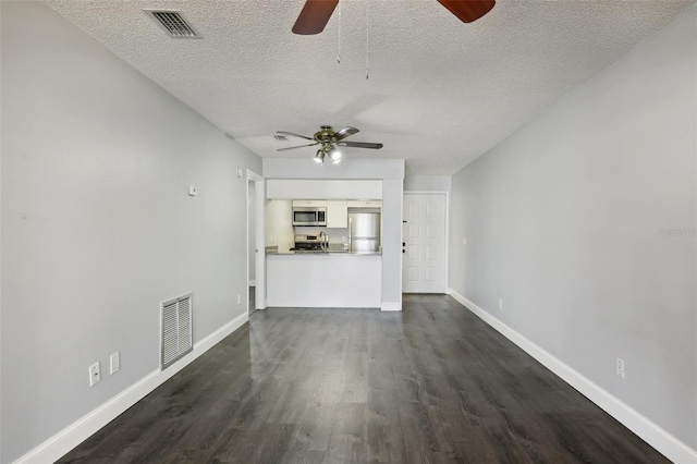 unfurnished living room with ceiling fan, a textured ceiling, and dark hardwood / wood-style floors