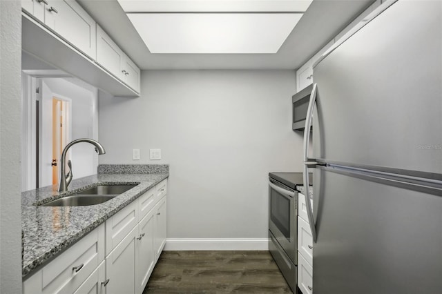 kitchen featuring white cabinetry, dark hardwood / wood-style flooring, appliances with stainless steel finishes, light stone counters, and sink