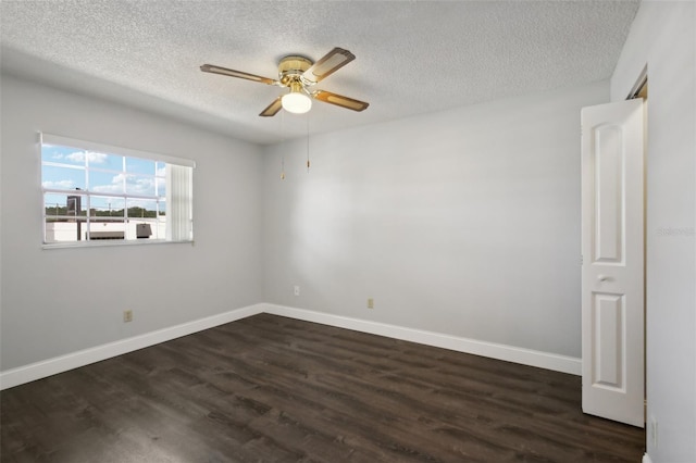 empty room with ceiling fan, dark hardwood / wood-style flooring, and a textured ceiling