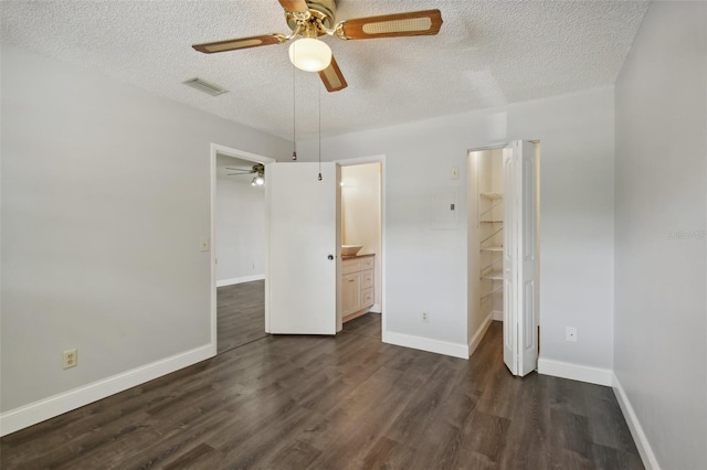 unfurnished bedroom with a closet, ceiling fan, dark hardwood / wood-style flooring, and ensuite bath