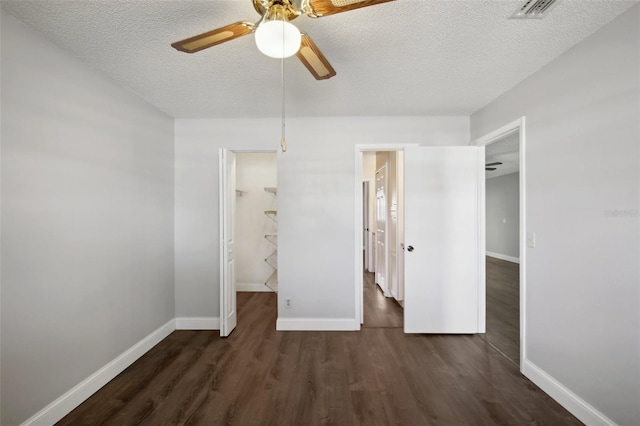 unfurnished bedroom with a textured ceiling, a closet, ceiling fan, and dark hardwood / wood-style floors