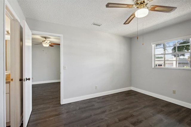 empty room with ceiling fan, a textured ceiling, and dark wood-type flooring