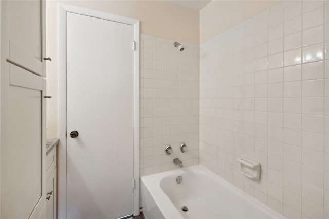 bathroom featuring tiled shower / bath and vanity