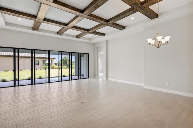 empty room featuring beamed ceiling, light wood-type flooring, coffered ceiling, and an inviting chandelier