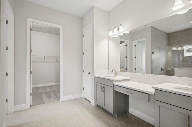 full bath with a stall shower, baseboards, tile patterned floors, a walk in closet, and vanity