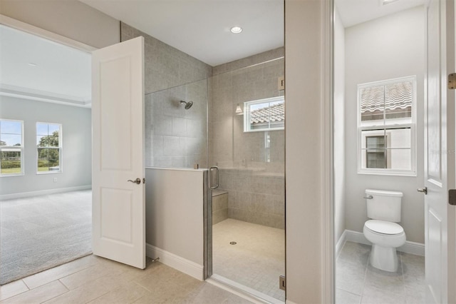 full bathroom featuring a wealth of natural light, a stall shower, toilet, and baseboards